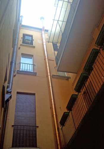 Canna fumaria in rame in un cortile interno a Bologna